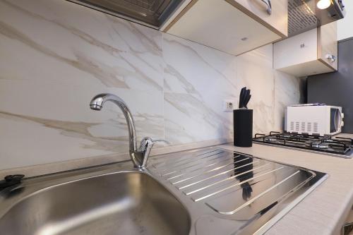 a kitchen with a sink and a counter top at Primopiano - Olgettina in Vimodrone