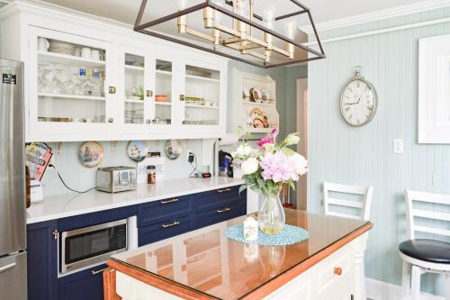 a kitchen with blue cabinets and a vase of flowers on a counter at The Jellybean Heritage Inn in St. John's
