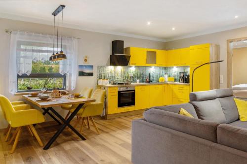 a kitchen and a living room with yellow cabinets at Ferienhaus Mond mit Sternenblick in Lochow