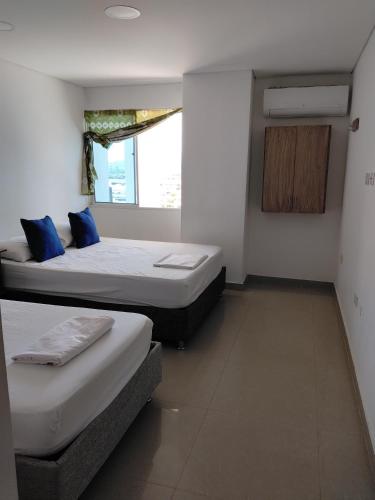 a bedroom with two beds and a window at Rodadero brisas marinas in Gaira