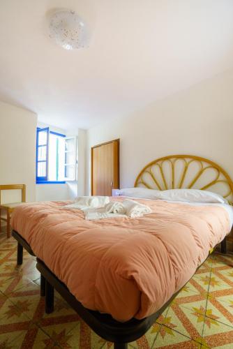 a bedroom with a large bed with an orange blanket at CaTorre 14 in Riomaggiore