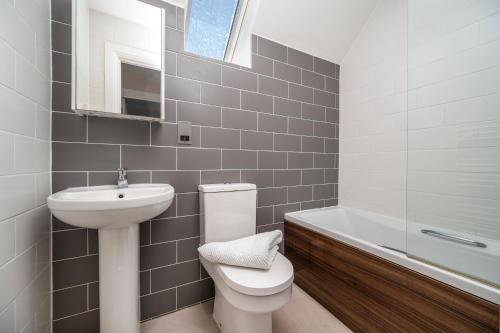 a bathroom with a toilet and a sink and a bath tub at Burnside, Dornoch in Dornoch