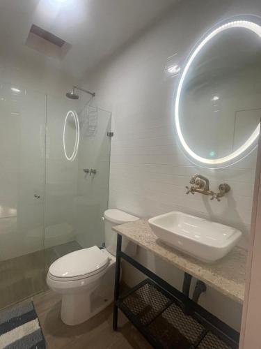 a bathroom with a sink and a toilet and a mirror at Apartartamento Centrico 27 Chapala in Chapala