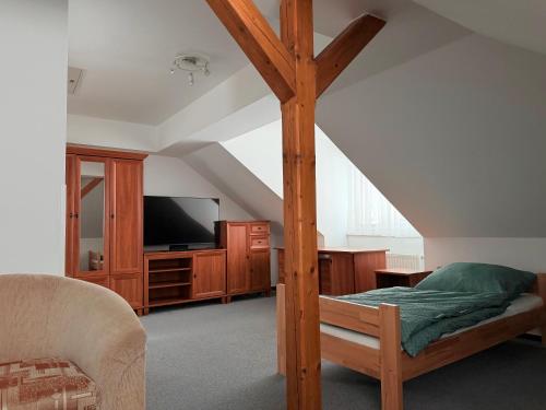 a bedroom with a wooden canopy bed with a tv at Chata pod Radhoštěm in Trojanovice