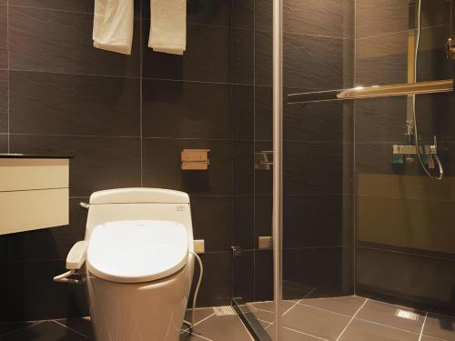 a bathroom with a toilet and a glass shower at Moving Star Hotel in Nan-tzu-ts'un