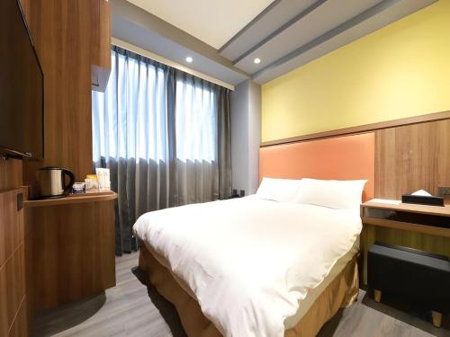 a bedroom with a large bed and a window at Moving Star Hotel in Nan-tzu-ts'un