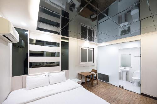 a bedroom with a white bed and a bathroom at Lien Hotel Haeundae in Busan