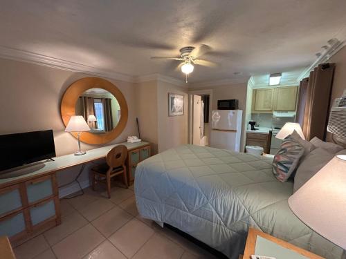 a bedroom with a bed and a desk and a kitchen at Sea Vista Motel in New Smyrna Beach