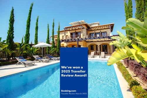 a villa with a swimming pool in front of a house at Luxury Elite Villa AJ04 complete with a private, climate controlled pool and a relaxing outdoor Jacuzzi, Aphrodite Hills Resort in Kouklia