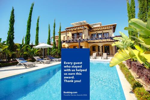 a sign in front of a house with a swimming pool at Luxury Elite Villa AJ04 complete with a private, climate controlled pool and a relaxing outdoor Jacuzzi, Aphrodite Hills Resort in Kouklia