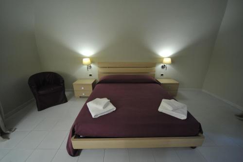 a bedroom with a bed and a chair and lights at Gatto Bianco House in Bari