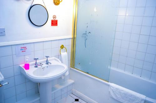 a bathroom with a sink and a shower at Ty Newydd Country Hotel in Hirwaun