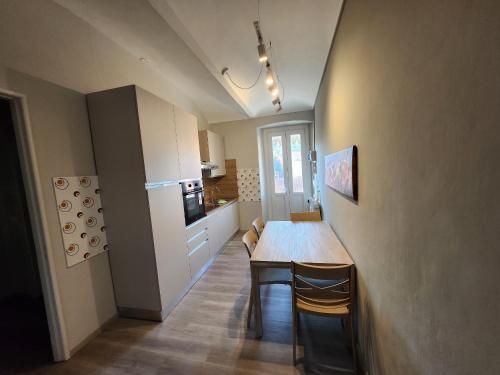a kitchen with a table and chairs in a room at Casa di ringhiera 1 in Pinerolo