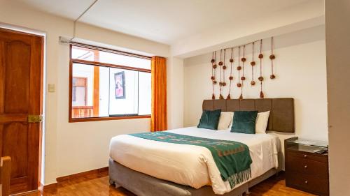 a bedroom with a large bed and a window at Munay Ñusta Cusco in Cusco