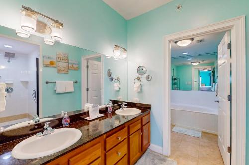 a bathroom with two sinks and a large mirror at Paradise Shores 200 in Mexico Beach