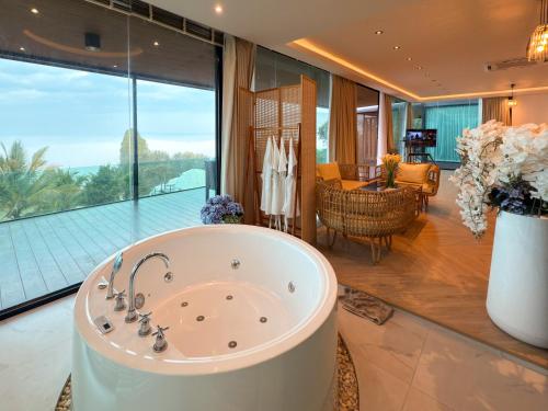 a bath tub in a room with a large window at Laguna Khaokho in Khao Kho