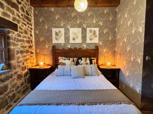 a bedroom with a bed with two nightstands and two candles at Cabaña Los Picones in Pisueña
