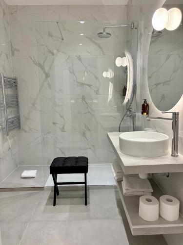 a white bathroom with a sink and a mirror at RIOSHOUSE Henley in Henley on Thames