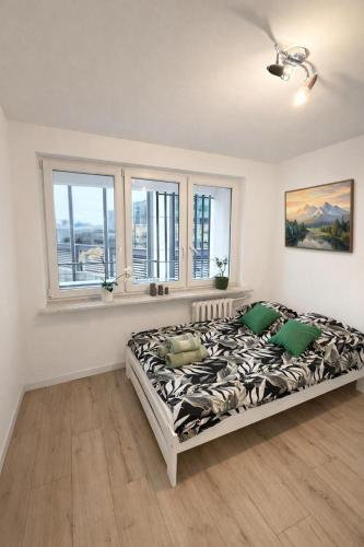 a bedroom with a bed in a room with windows at Chmielna Residence in Warsaw