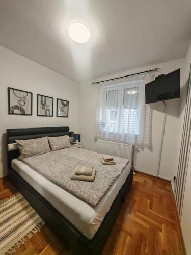 a bedroom with a bed with two towels on it at Apartman Harmonija Vrnjačka Banja in Vrnjačka Banja