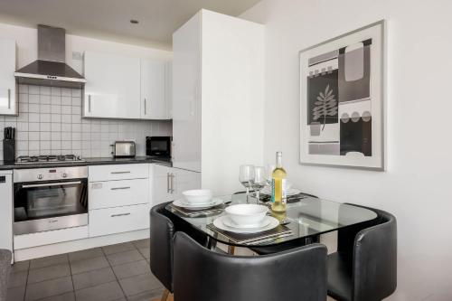 a kitchen with a table and black chairs in a room at Castle Lanes - Minutes from Poole Quay, Poole Town Location in Poole