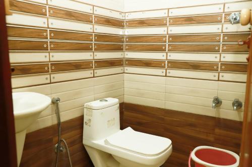 a bathroom with a toilet and a sink at Clement homes in Kalpetta