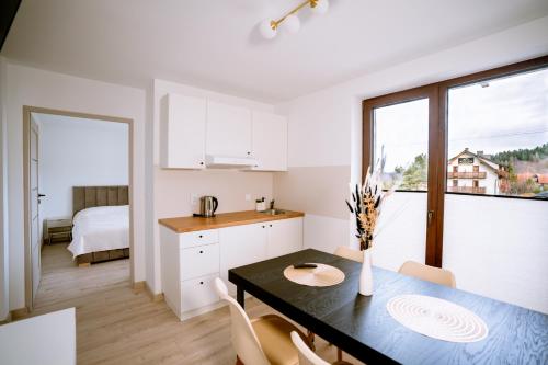 a kitchen and dining room with a table and chairs at Aldian Pokoje Gościnne in Szczyrk