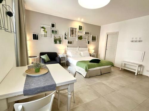 a bedroom with a bed and a table and a room at Giardino Botanico in Ragusa