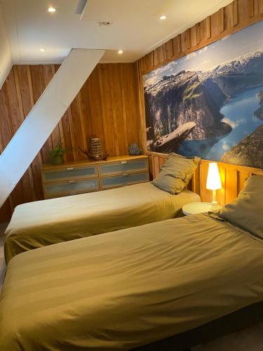 two beds in a room with a painting on the wall at 't Hof van Wespert in Westdorp
