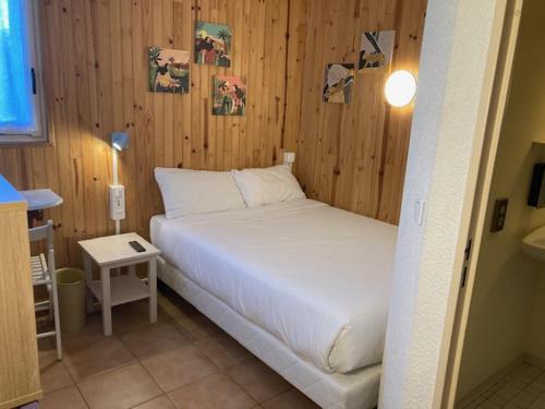 Un pat sau paturi într-o cameră la Le Rialto Hôtel Parc Des Expositions
