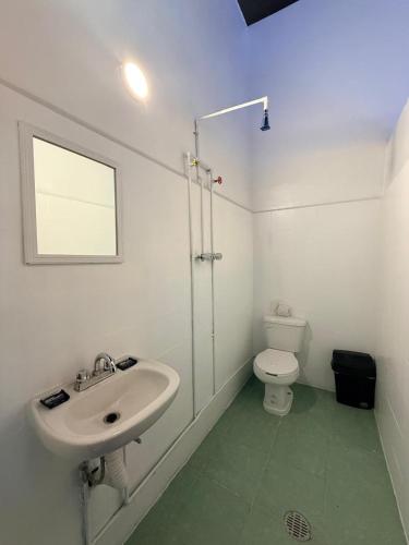 a white bathroom with a sink and a toilet at Hotel Zamora Downtown CDMX in Mexico City