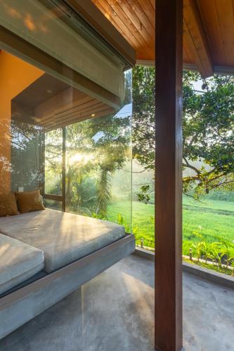 a bedroom with a bed and a large window at ONA Garden Villa in Galle
