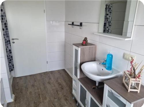 a white bathroom with a sink and a mirror at Gästewohnung Rauw in Saint-Vith