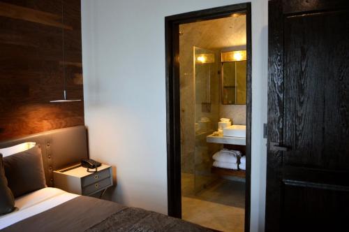 a bedroom with a bed and a bathroom with a sink at Dos Casas Hotel & Spa in San Miguel de Allende