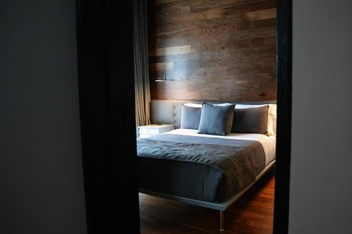 a bedroom with a bed with a wooden wall at Dos Casas Hotel & Spa in San Miguel de Allende