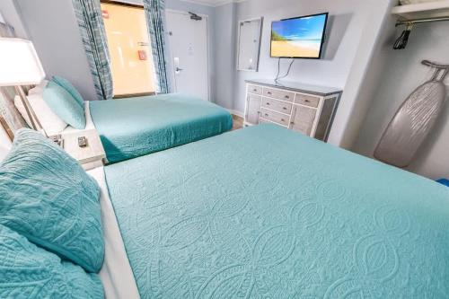 a small bedroom with two beds and a television at Prime Ocean Frontage The Pavilion in Myrtle Beach