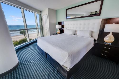 a bedroom with a bed with a view of the beach at Seaside condo w hot tub & private balcony in Myrtle Beach