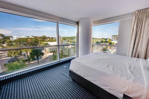 a bedroom with a bed and large windows at Seaside condo w hot tub & private balcony in Myrtle Beach