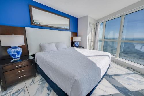 a bedroom with a large bed and a large window at Amazing Oceanfront 2BR condo with pools and views in Myrtle Beach