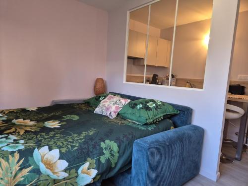 a bedroom with a bed with a blue couch and a mirror at Ty Joty in Perros-Guirec