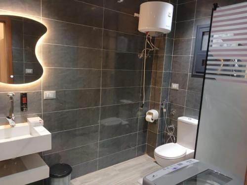 a bathroom with a shower with a toilet and a sink at Elmandara Residence in Alexandria