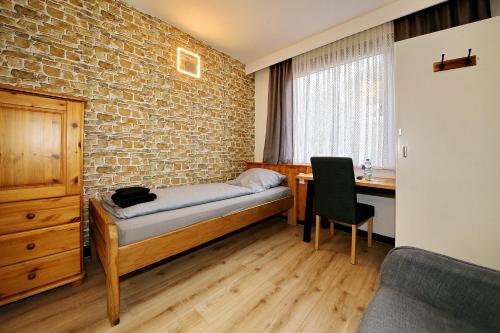 a bedroom with a bed and a brick wall at Pension Haus Sonneck in Wildemann