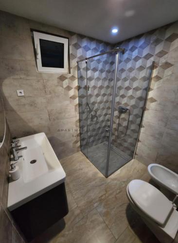 a bathroom with a shower and a sink and a toilet at Apartments Bulatovic in Budva