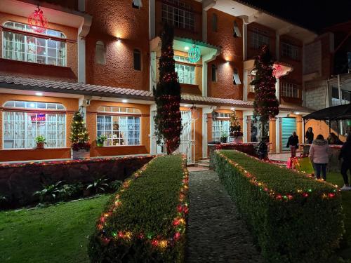 a building with christmas lights and hedges in front of it at Hotel LaLoma in San Miguel Regla