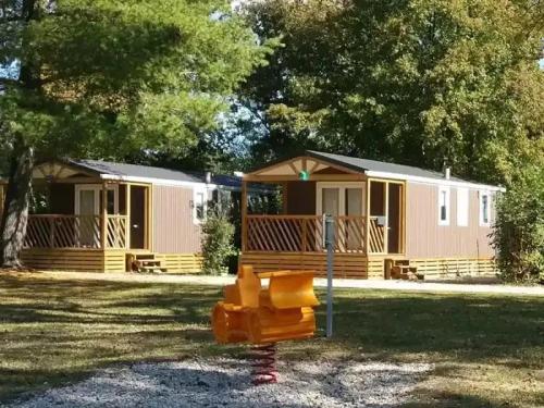 a couple of mobile homes in a yard with at ZEcamping 3 étoiles familial pet friendly avec piscine et restaurant in Sandrans