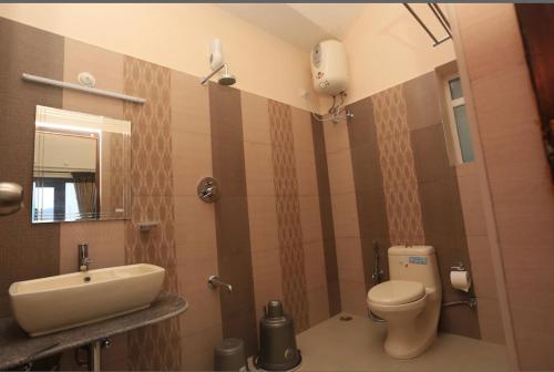 a bathroom with a toilet and a sink at Paradise Perfect - Nonsmoking Non alcoholic No unmarried couples in Ooty