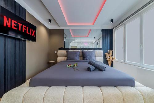 a bedroom with a king sized bed with a netflix sign at Escapade à deux à 10mn de Paris in Gentilly