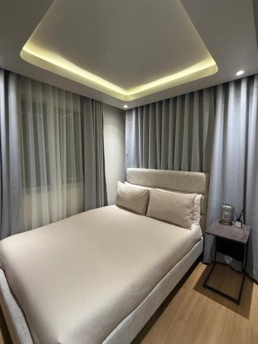 a bedroom with a large white bed with a ceiling at 1413 Home Suites Arezzo Place Davao in Davao City