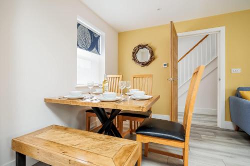 a dining room with a wooden table and chairs at Charlotte Cottage - Minutes from Poole Park, with Feature Log Burner in Poole