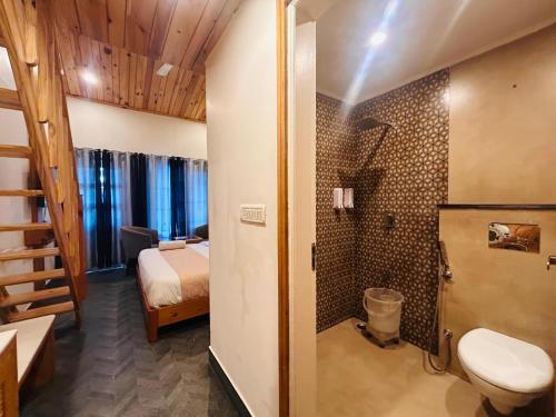 a bathroom with a toilet and a bed in a room at The Grand Dwaper A- Luxury Rooms & Parking Walking Distance From Mall Road in Mussoorie